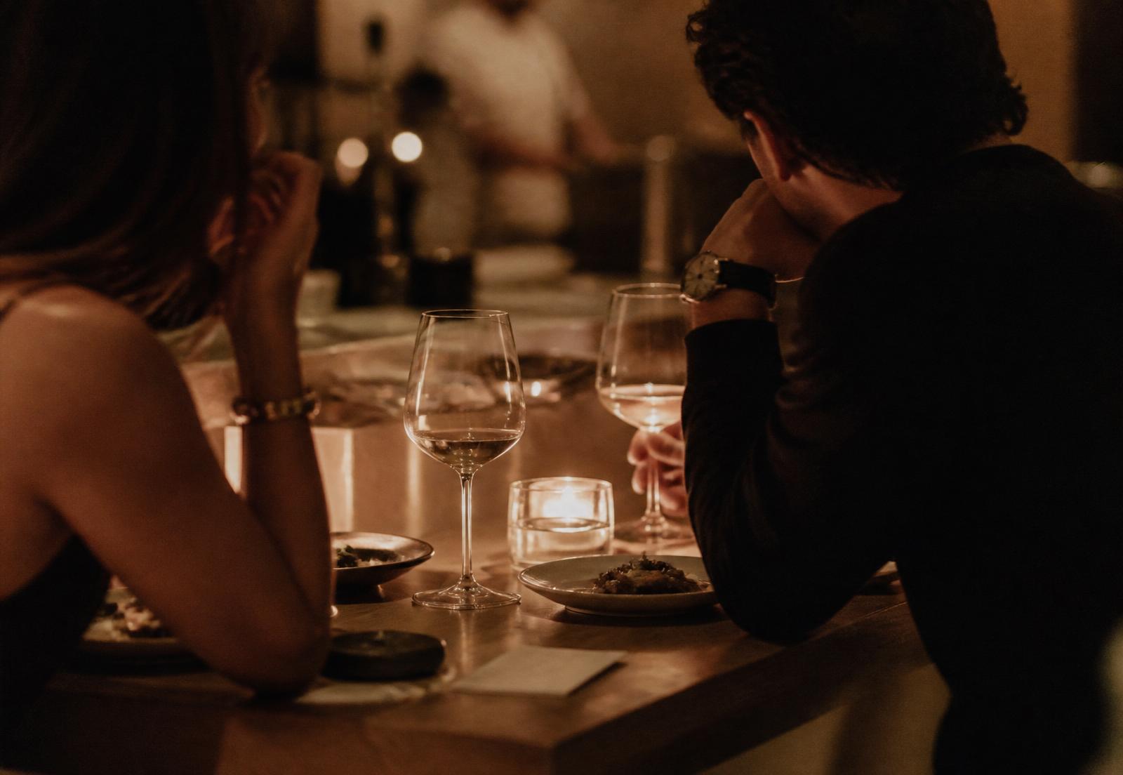 Intimate dinner conversation in warm candlelight